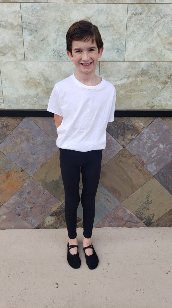 a boy in a white tshirt and black leggings for ballet