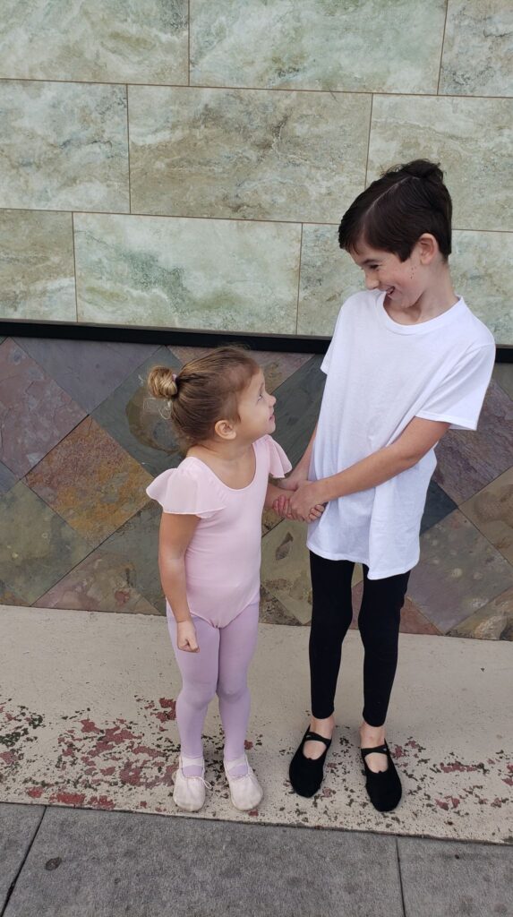 a boy doing ballet with his sister