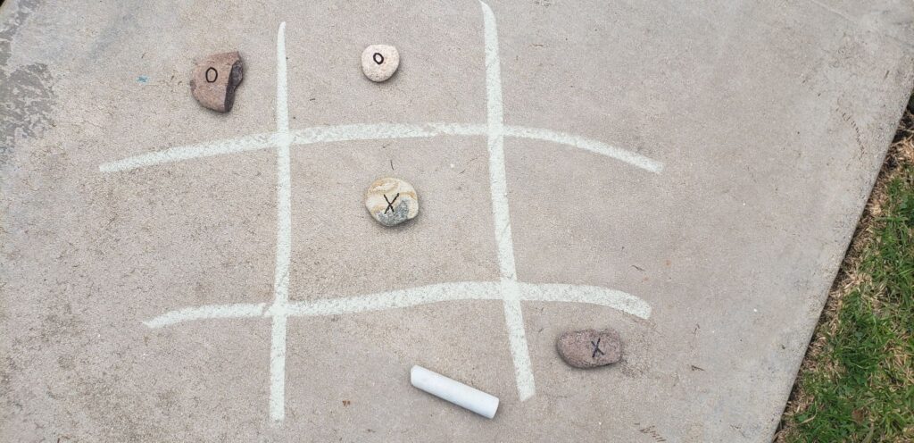 rocks with x and os written on them; tic tac toe lines