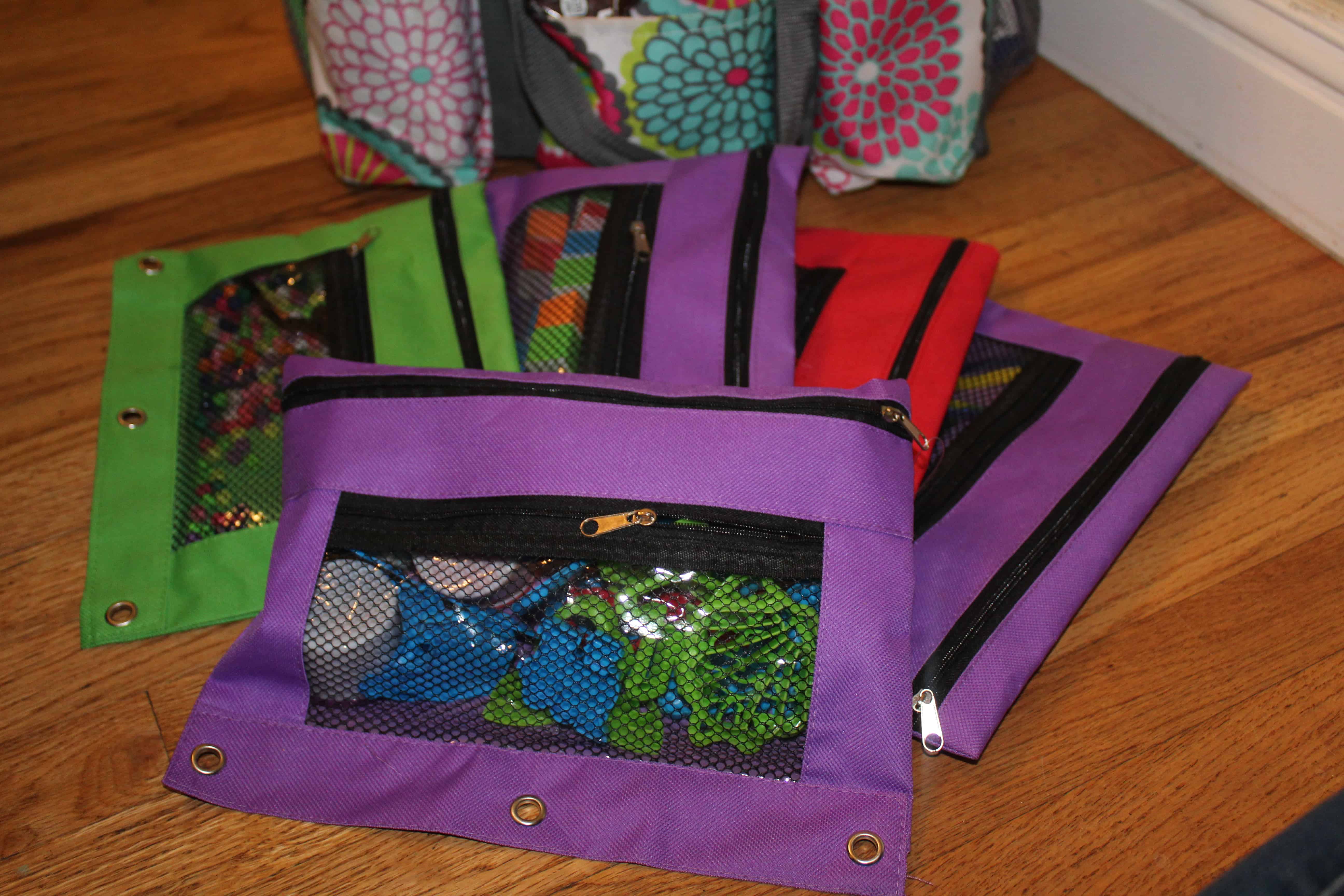 3 ring binder pencil pouches filled with extra toys and items for activities. 