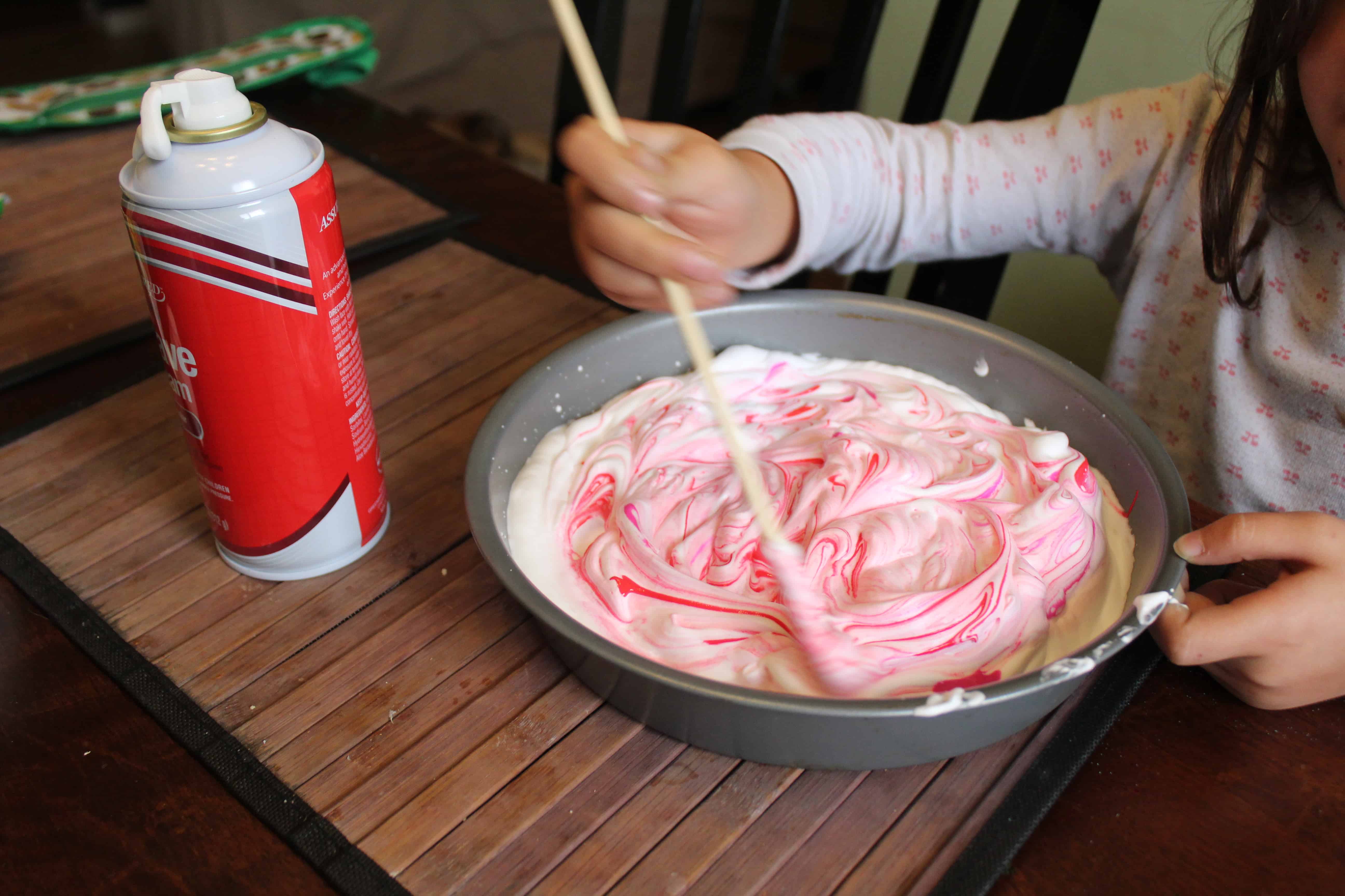 preschooler mixing paint into shaving cream