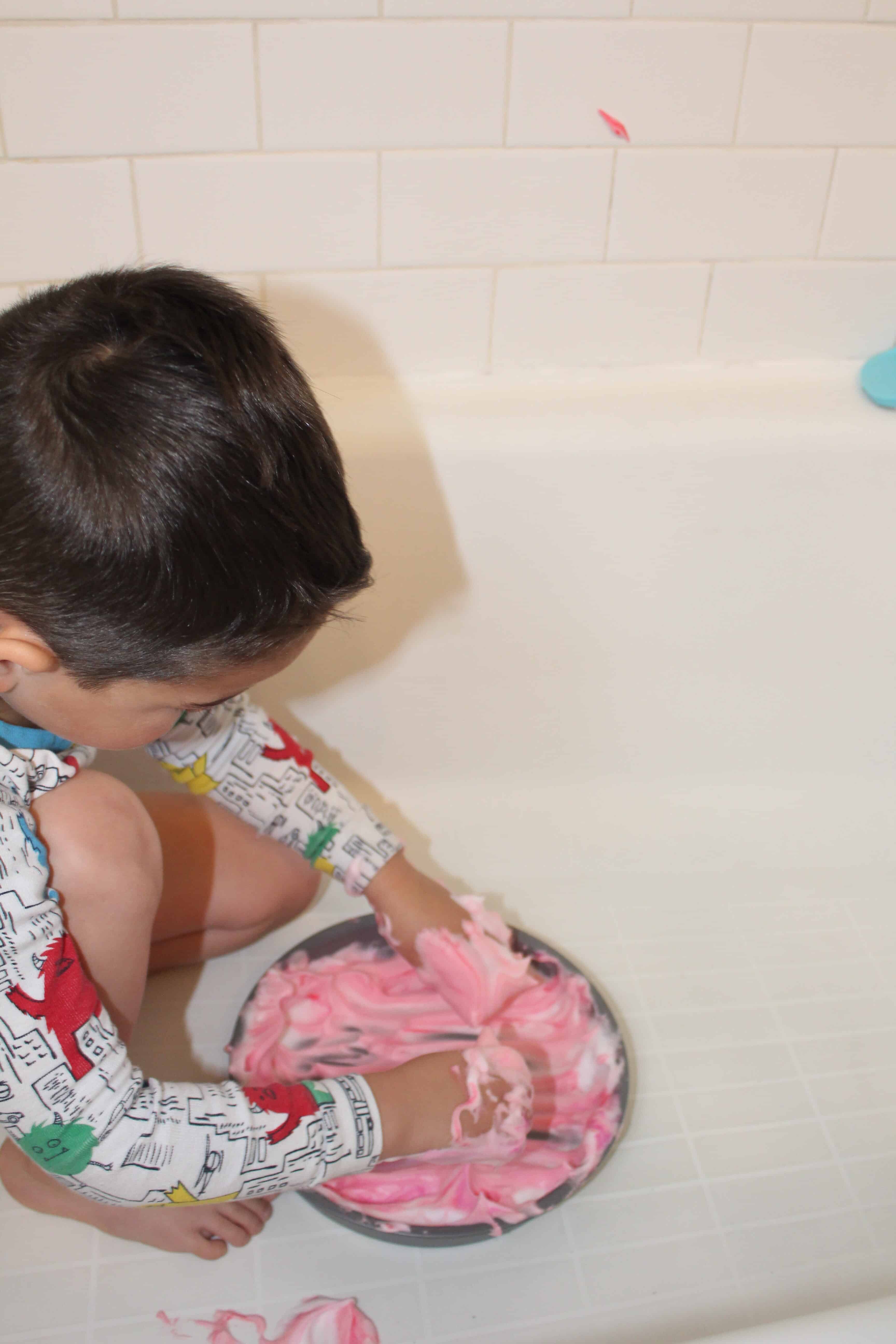 preschooling playing with shaving cream paint in tub