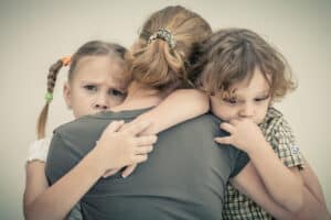 mom comforting kids after the death of a grandparent