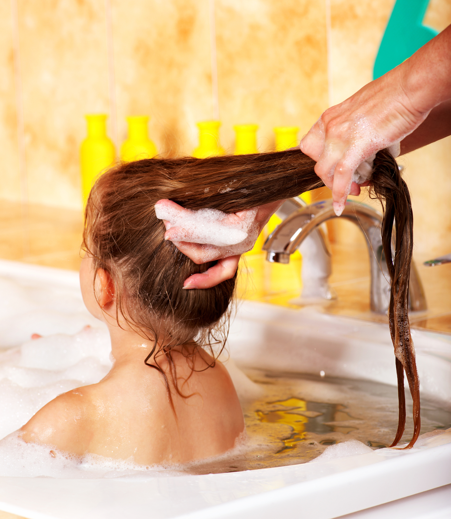 mom putting hair mask in daugheter's hair