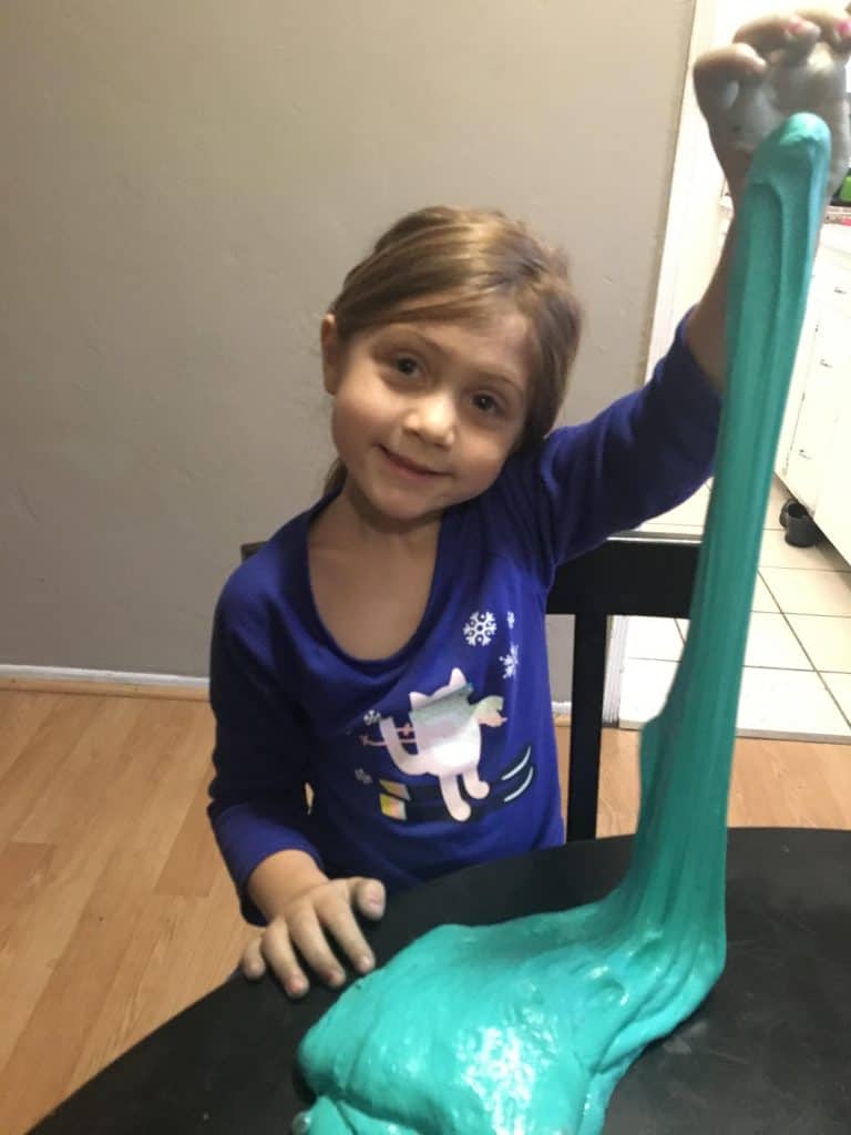 Young child stretching and kneading slime