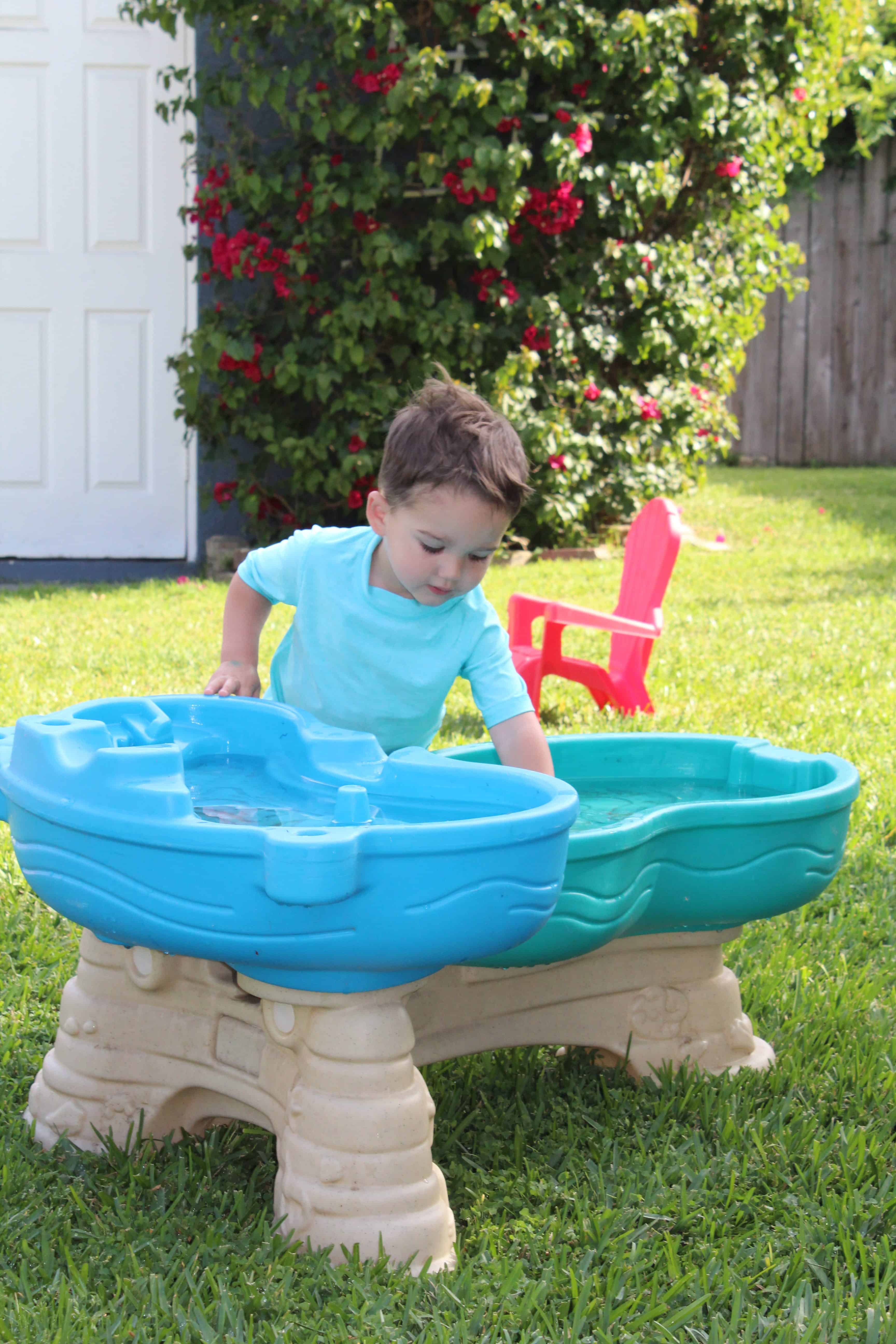 Toddler playing in water table. 