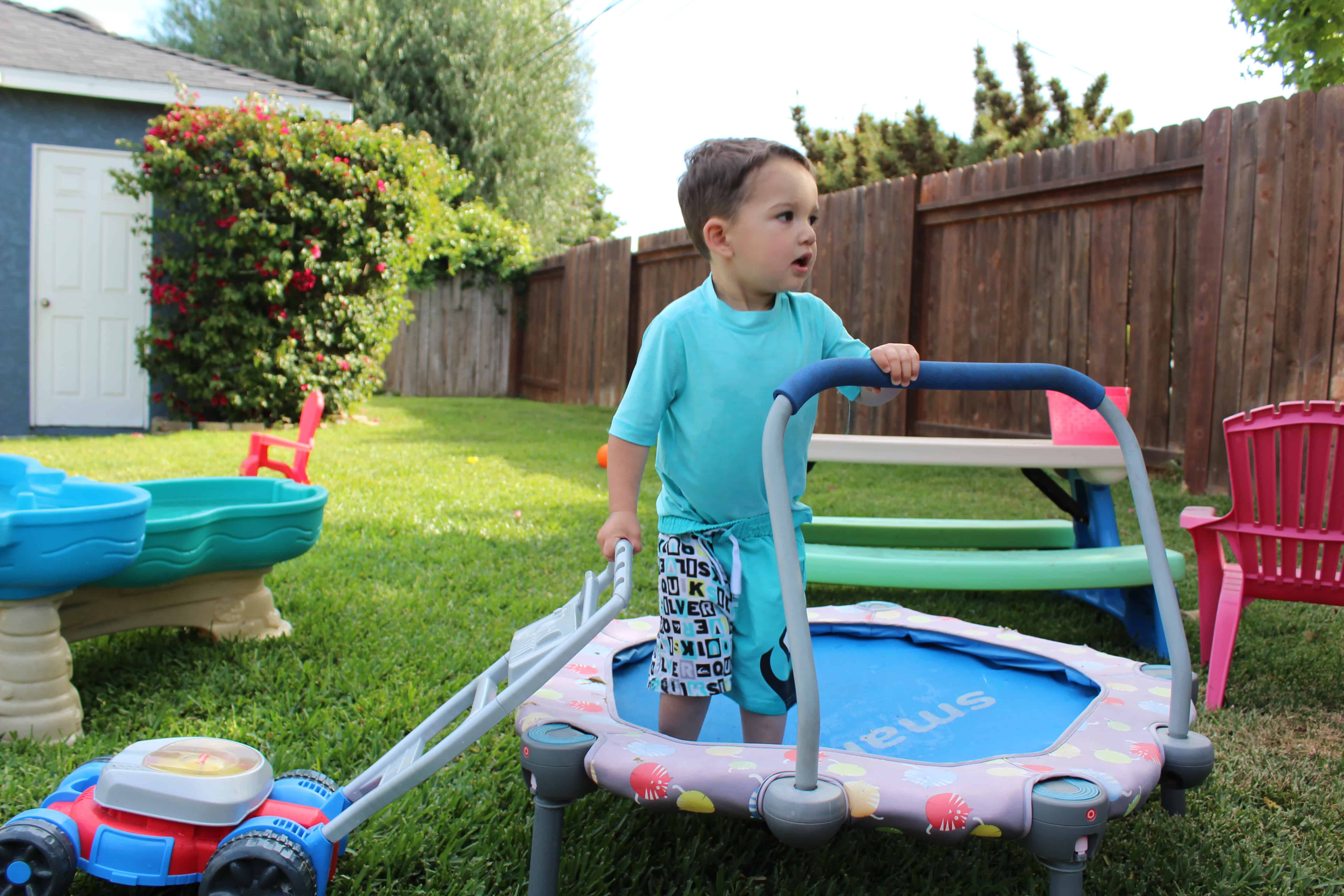 Toddler standing on mini trampoline