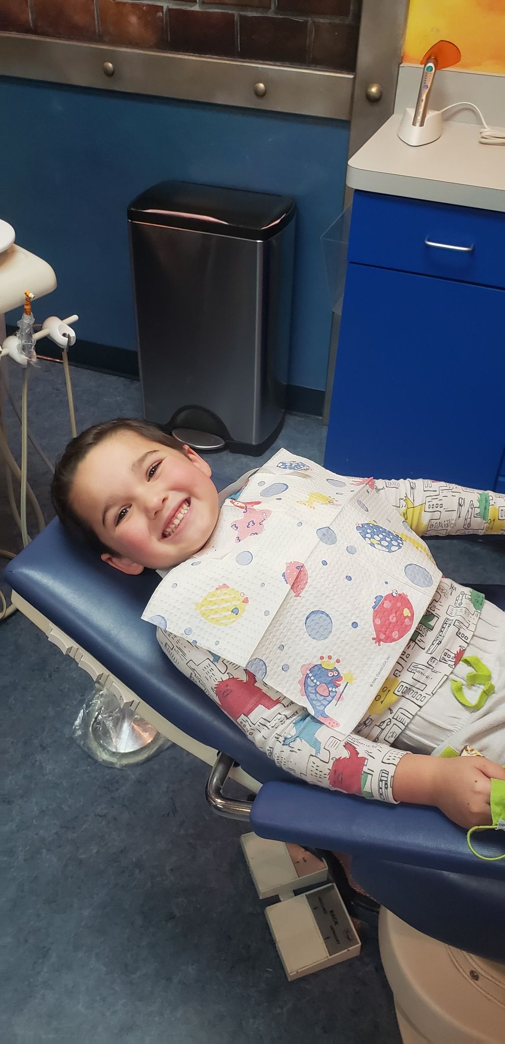 toddler smiling in dentist chair