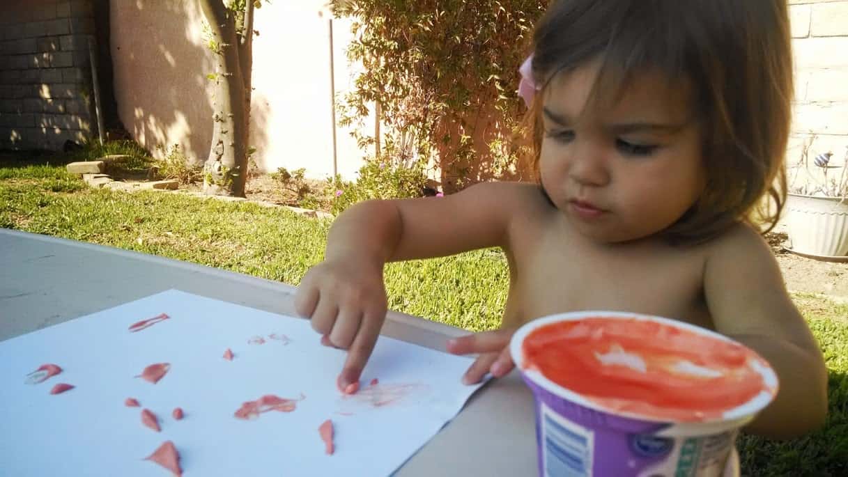 baby using yogurt finger paint