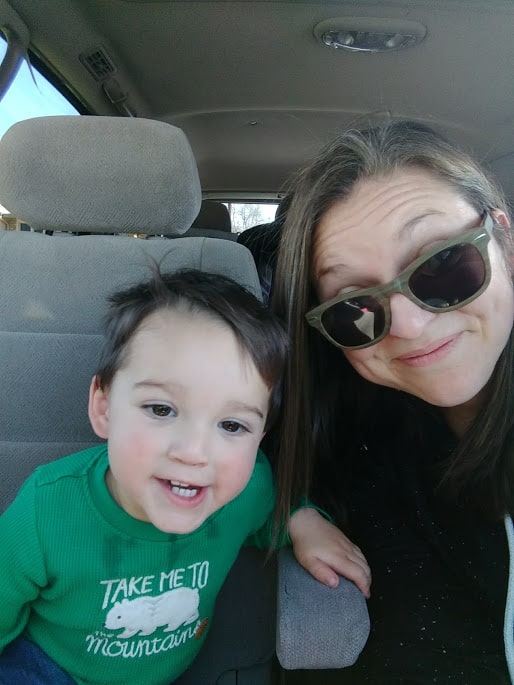 Smiling Toddler next to his mother.