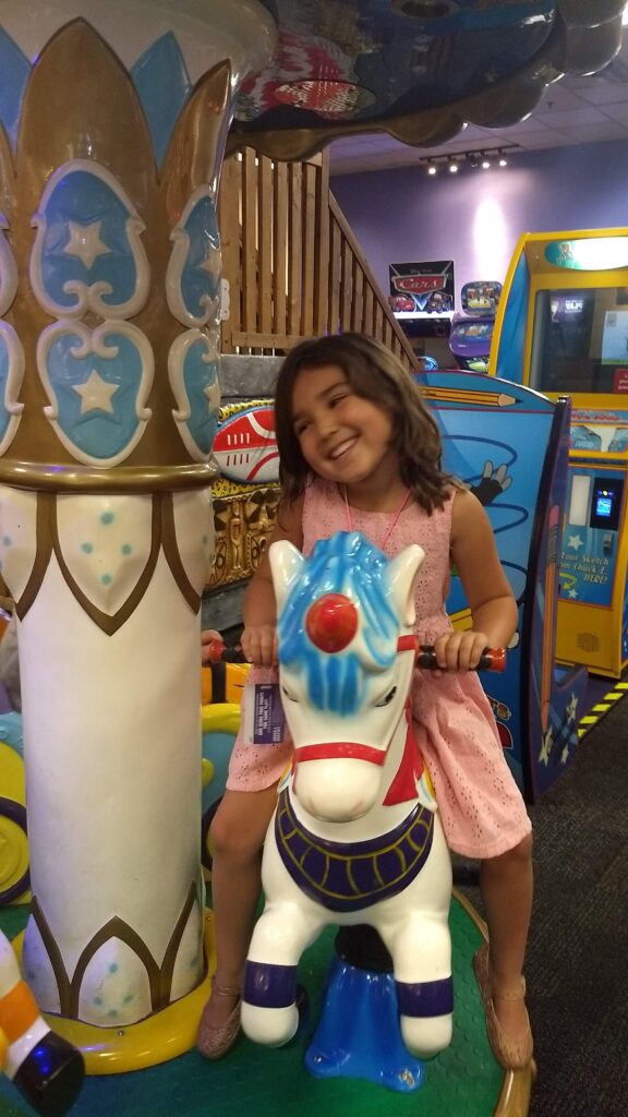 little girl on chuck e cheese ride