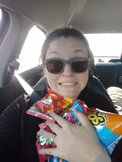 Salty mama with loads of snack sitting in the passenger side of a vehicle.