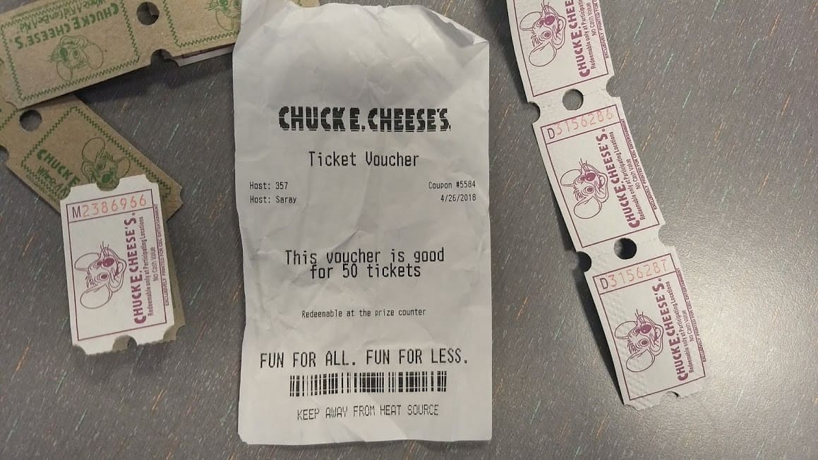 A picture of Chuck E. Cheese receipt and tickets