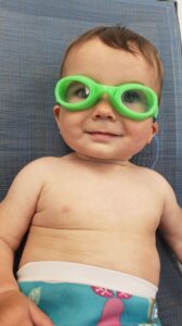 Baby wearing FINIS brand goggles for a day at the pool with kids