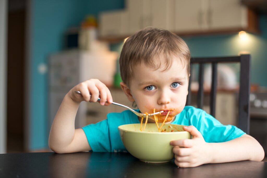 toddler boy eating spaghetti