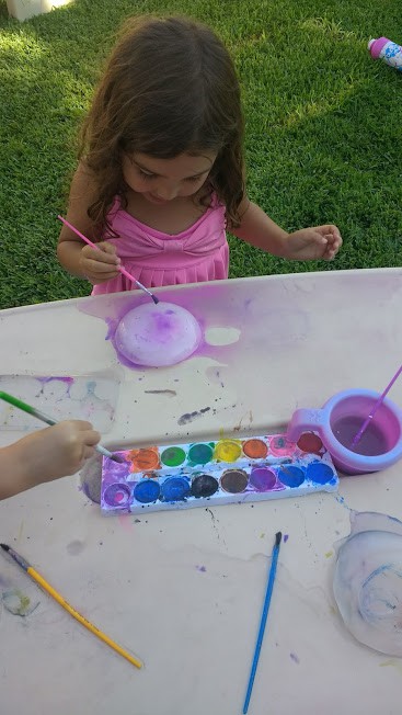 Toddler with watercolor paints painting ice