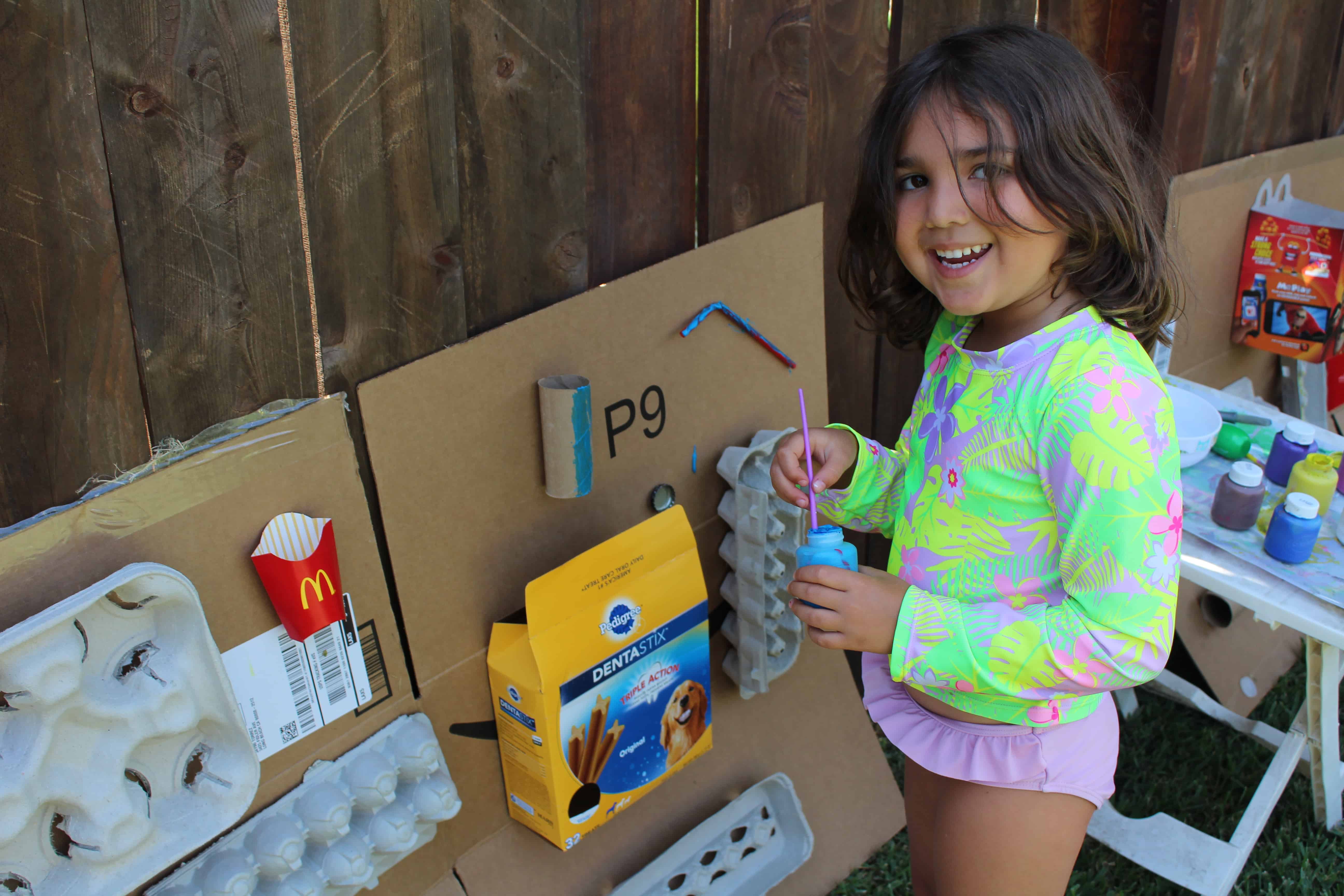Little girl using recycled materials to create art projects
