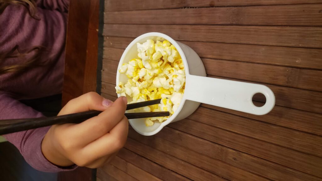 eating popcorn with chopsticks