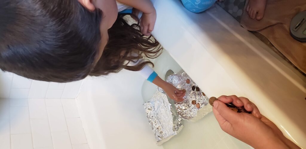 kids making boats with tin foil