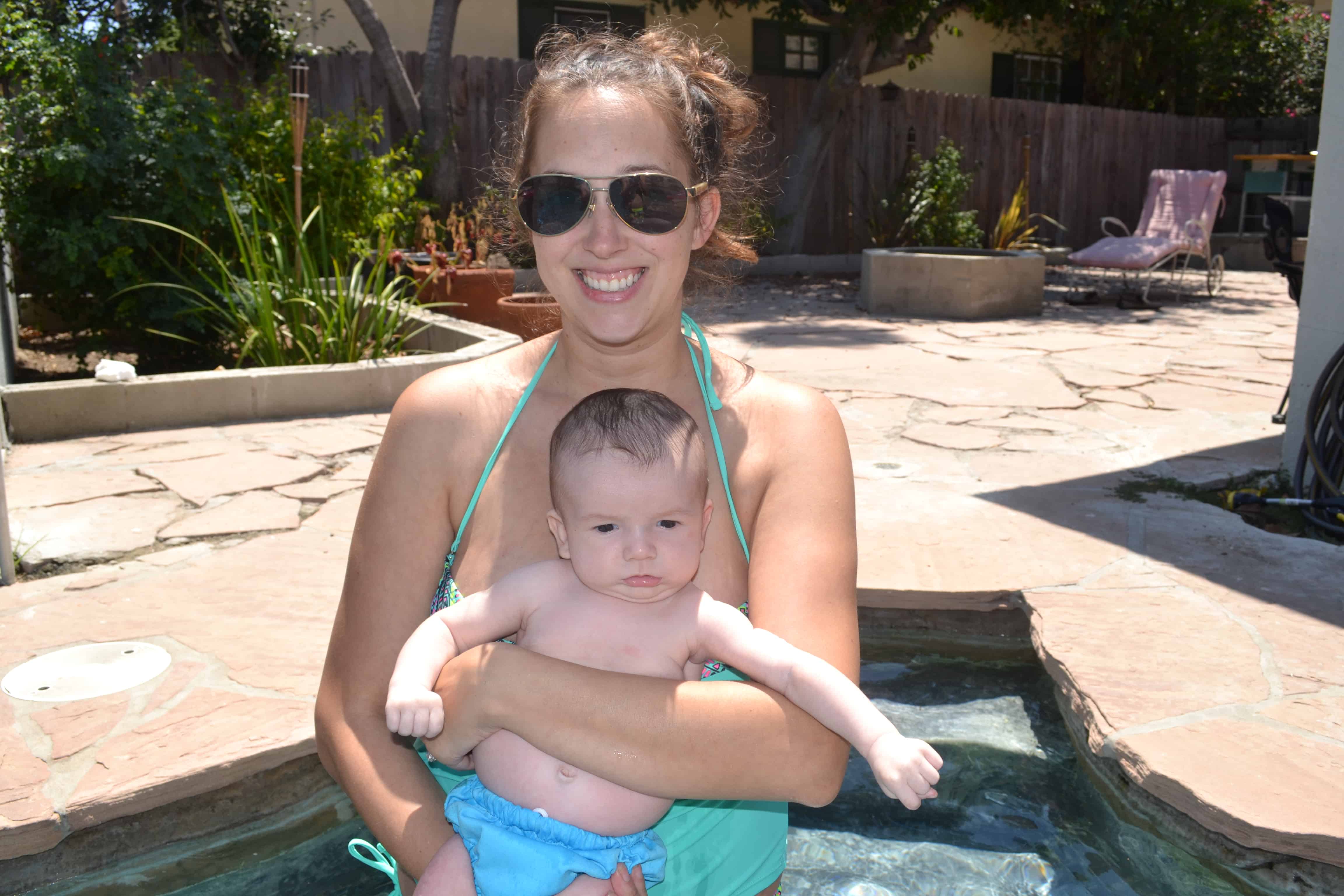 Smiling mother with a toddler by poolside