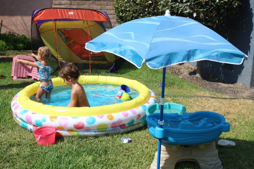 young toddler and preschooler in an inflatable kiddy pool