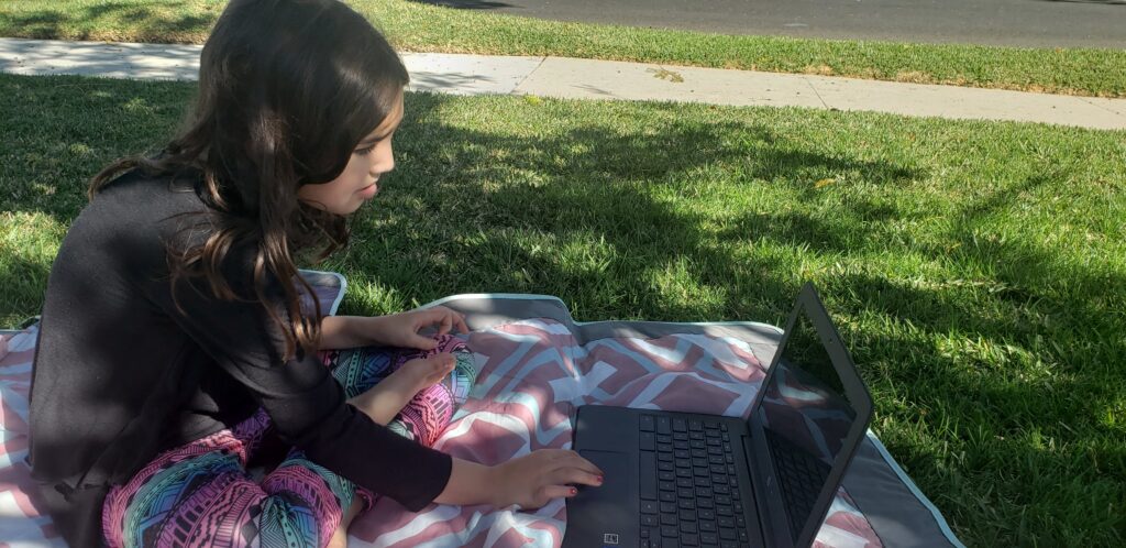 child doing their homework outside