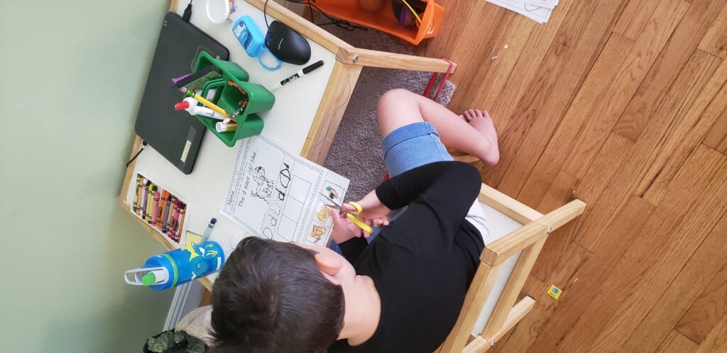 preschooler cutting a worksheet