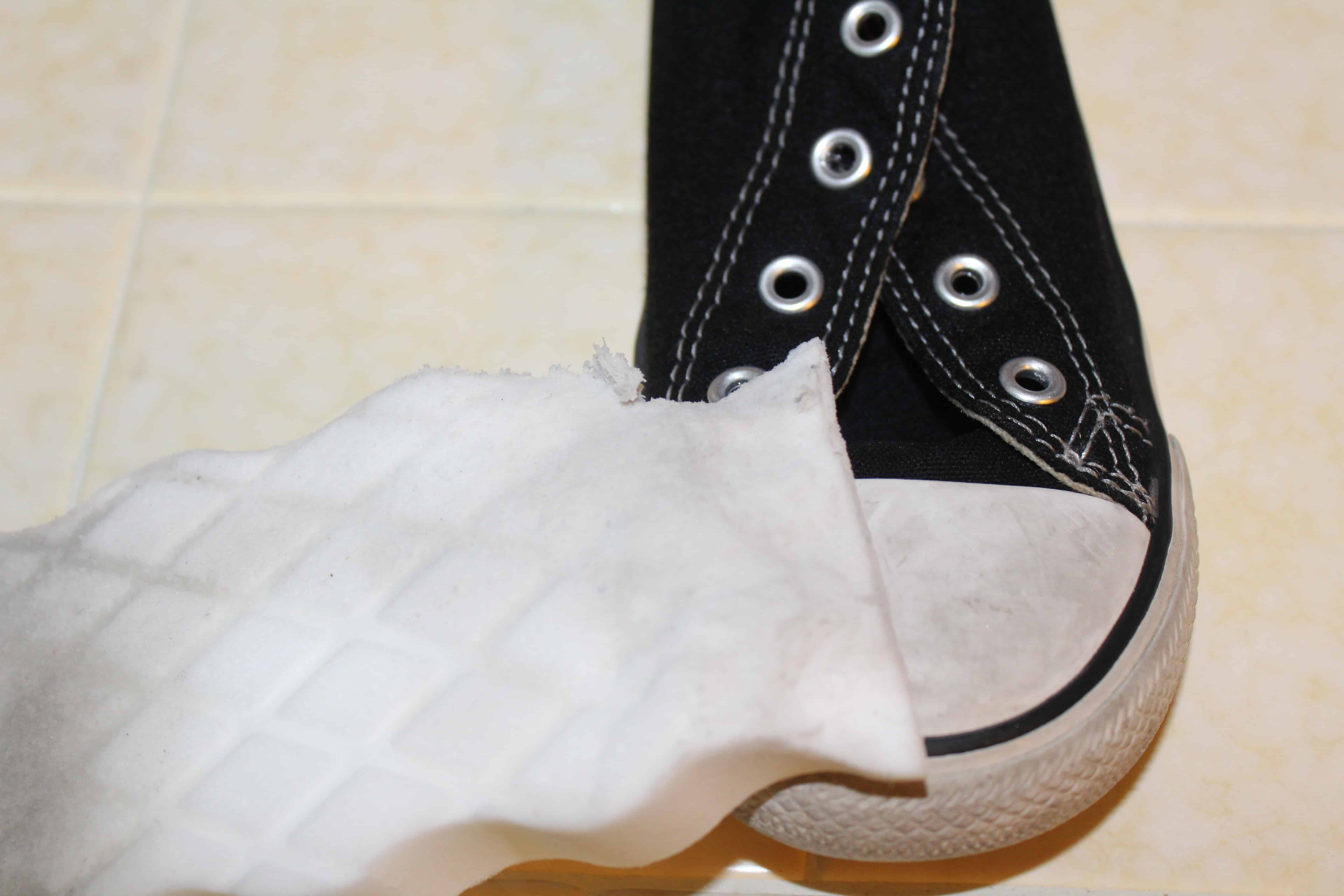 A magic clean eraser sitting on top of a pair of converse.