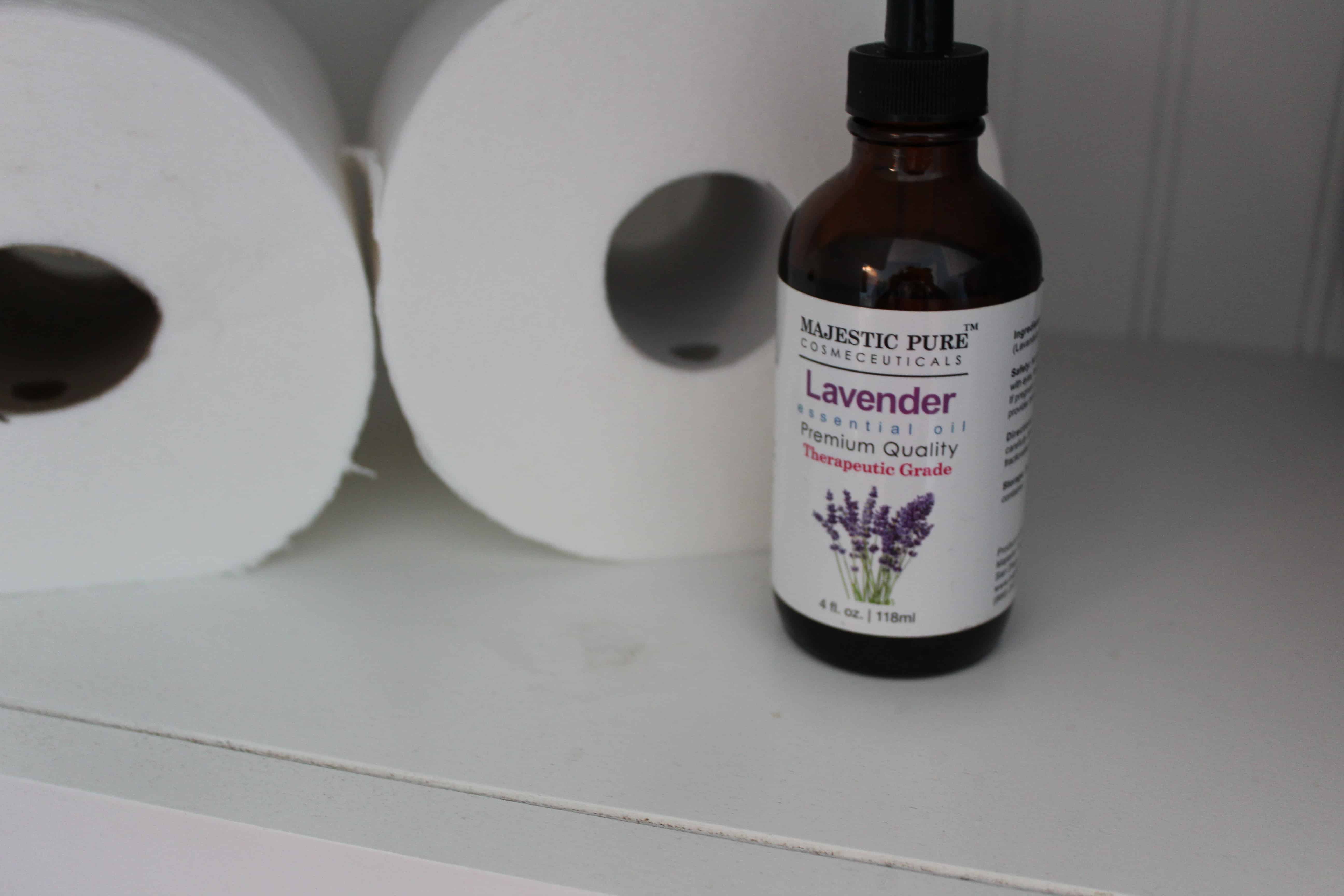 Stacked toilet paper rolls with a small bottle of lavender essential oils