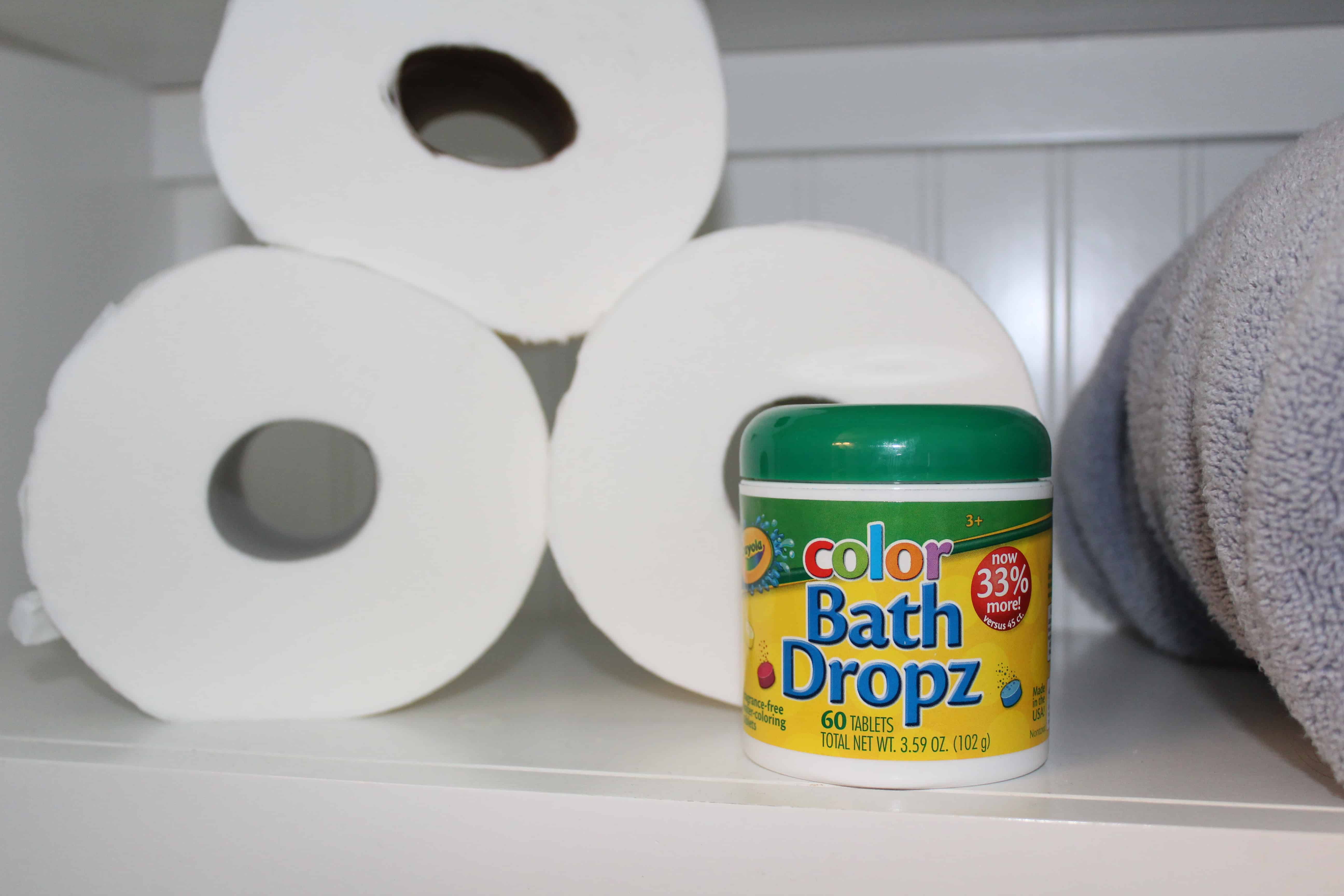 Toilet paper rolls and a container of Color Bath Dropz tablets