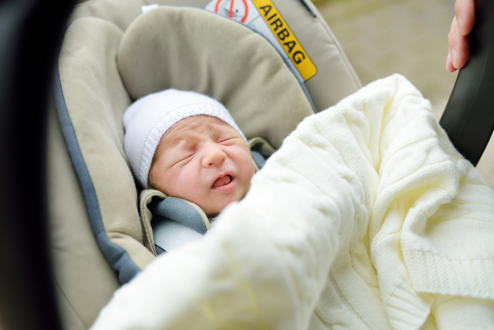 baby crying in a car seat