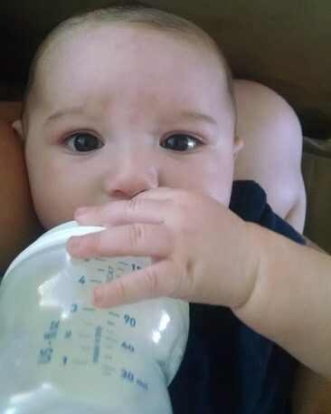 baby drinking a bottle, looking mad