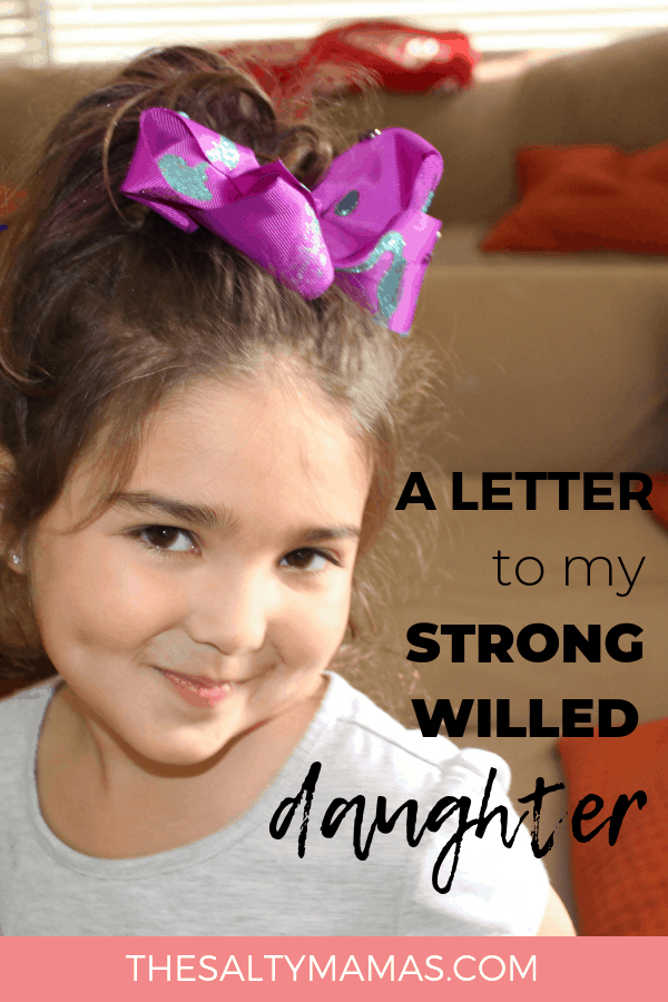 Smiling Girl with a bow in her head. Text overlay: A letter to my strong willed daughter. 