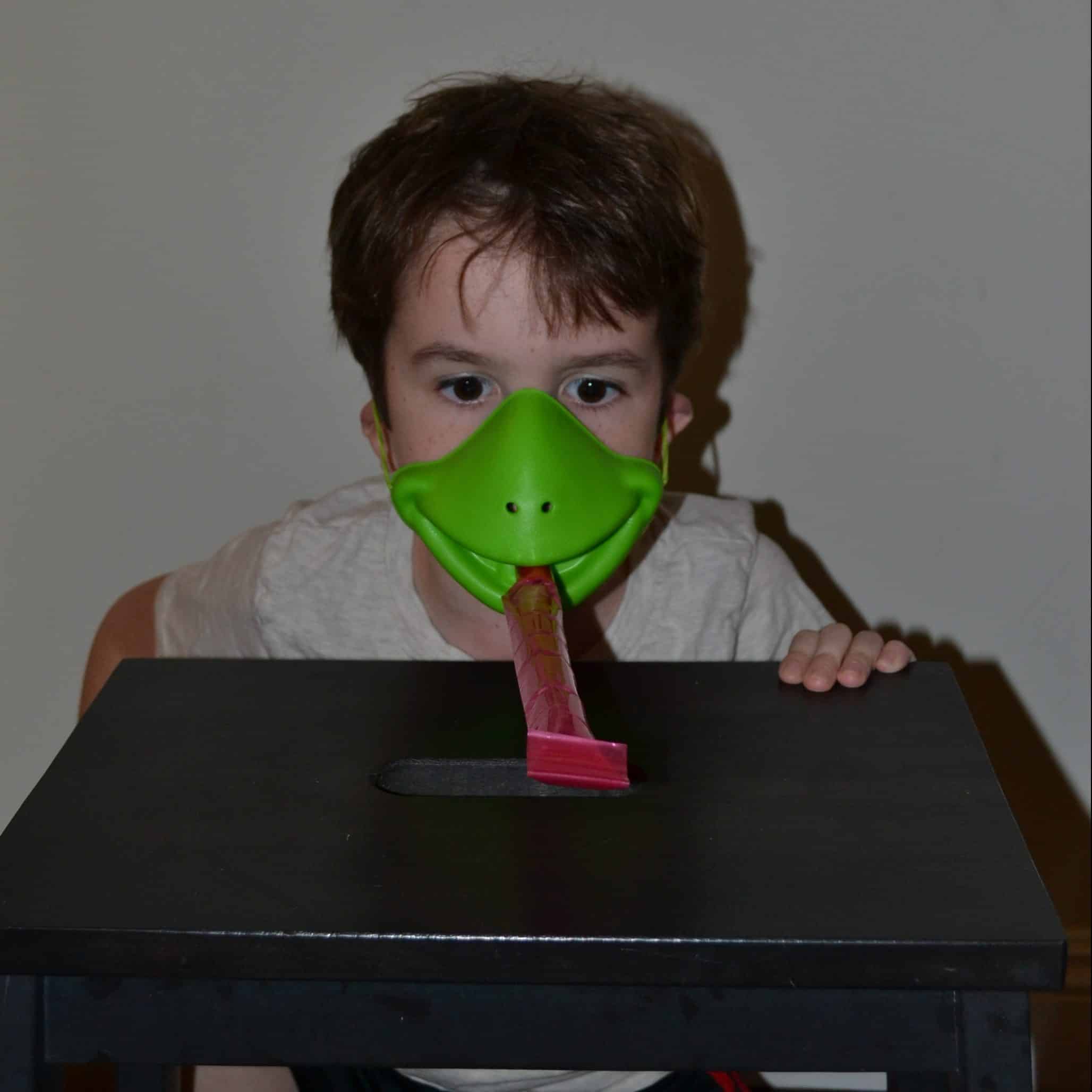 child wearing tic tac frog mask