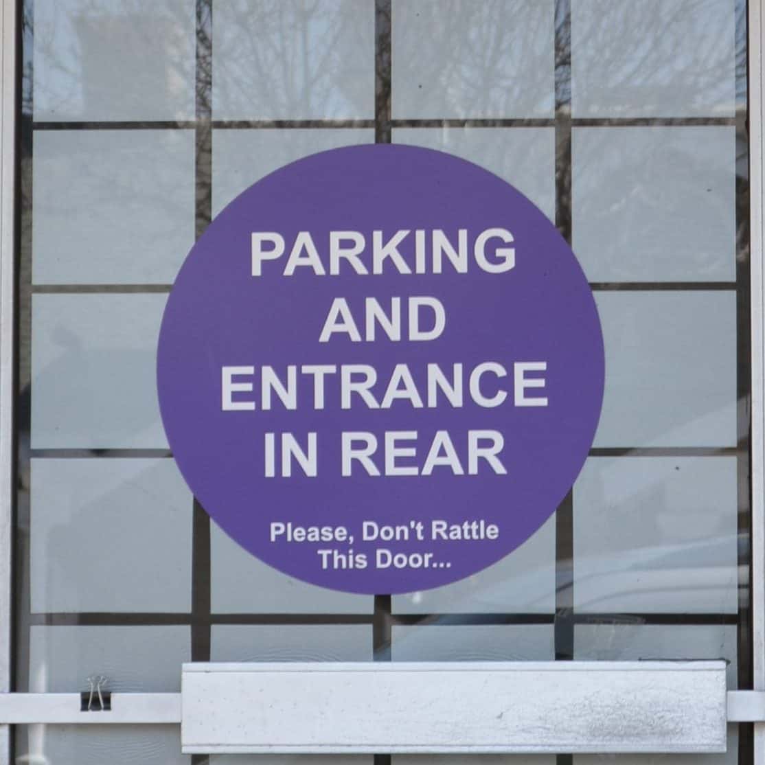 sign on door: parkign and entrance in rear