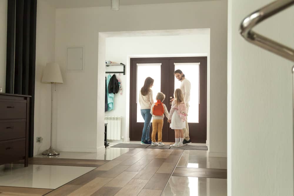 Family standing at the front door getting ready to leave