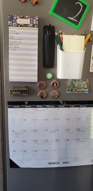 a calendar and tools on a fridge