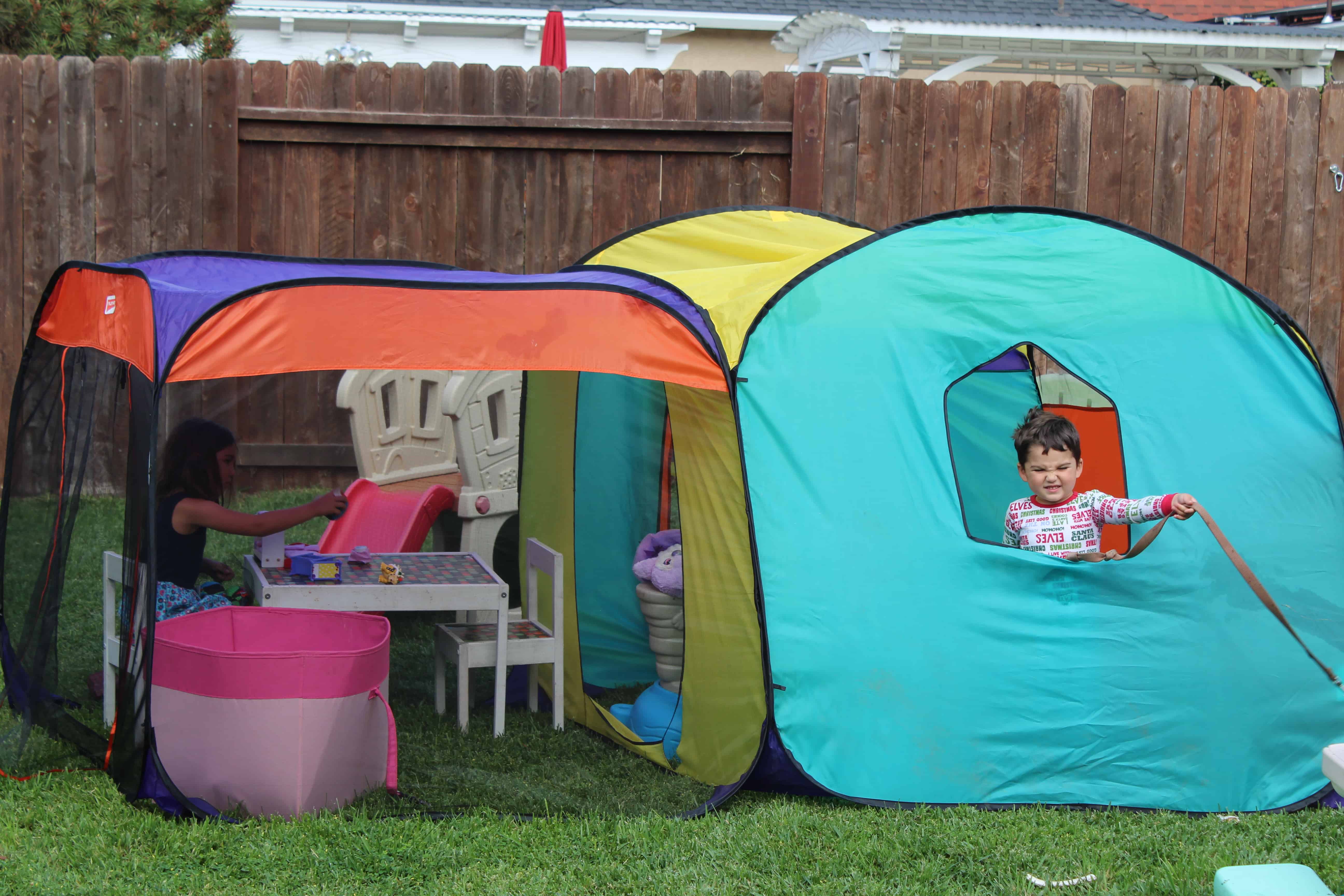 Two kids playing with their cool toys(forts) in the backyard.