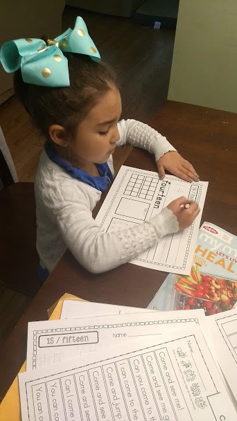 Child sitting at table filling out her nightly homework routine.