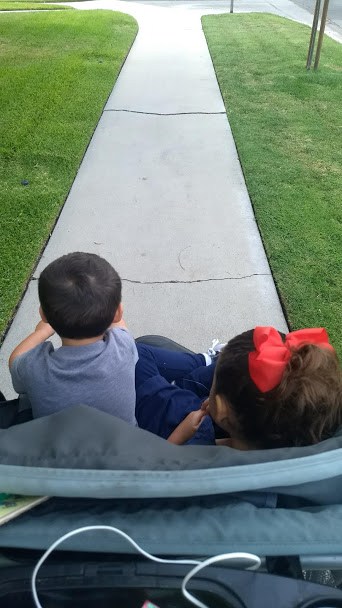 Two children in a double jogging stroller.