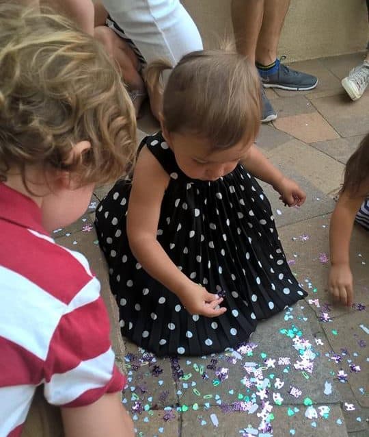 Toddlers playing with confetti at a gender reveal party