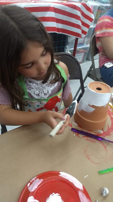 daughter painting a flower pot at michaels