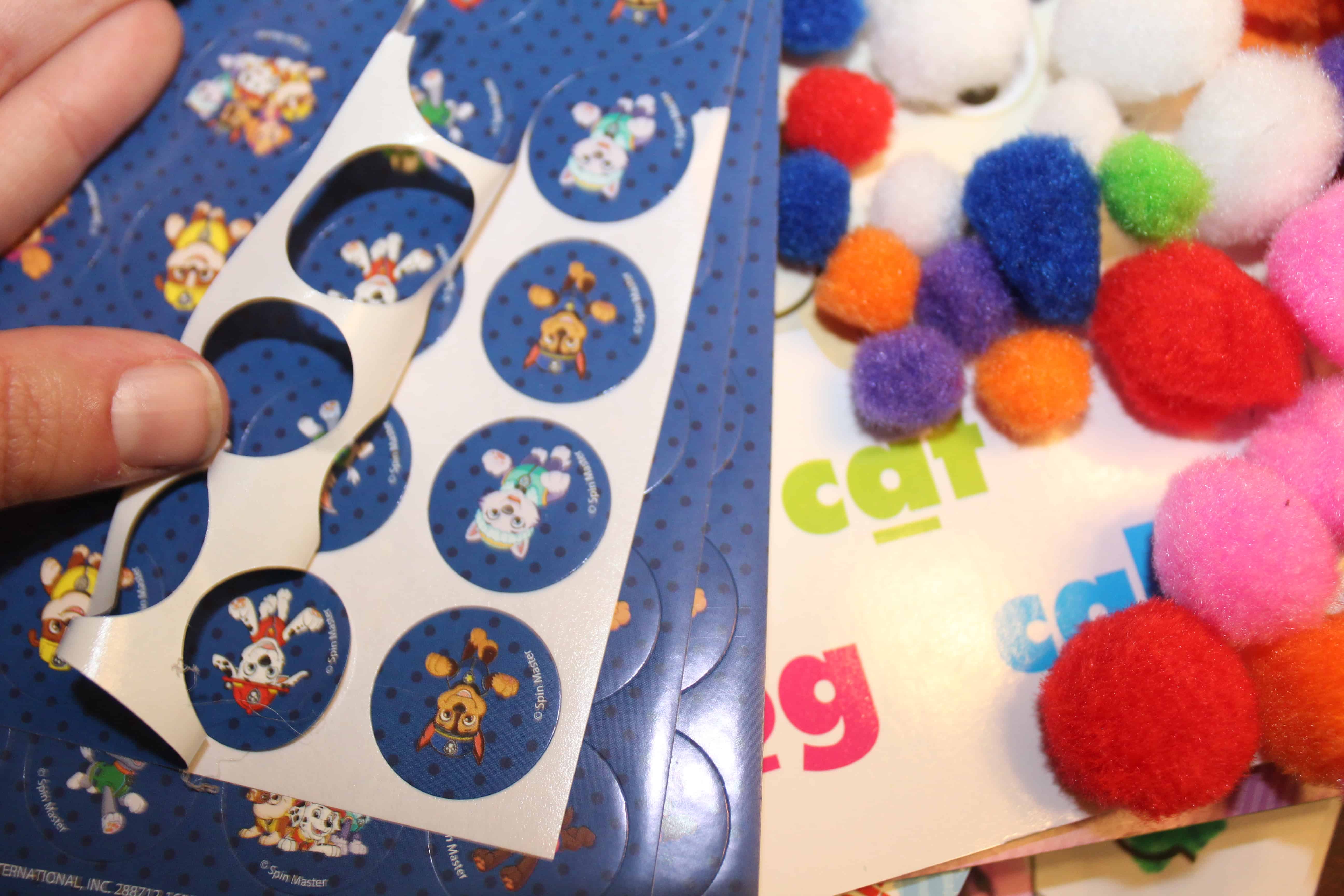 Regular stickers with boarder being removed and colored cotton balls. 