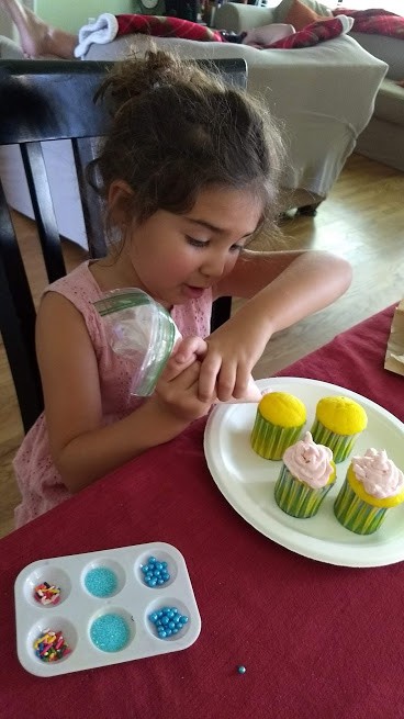 preschooler decorating cupcakes