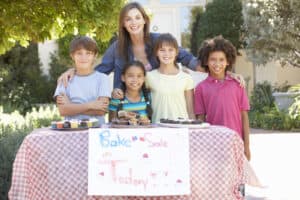 mom helping kids at a bake sale