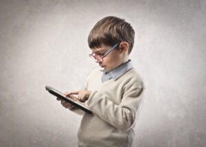 little boy reading an ebook on a tablet