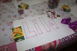 Big block letters spelling a name, with crayons sitting next to it