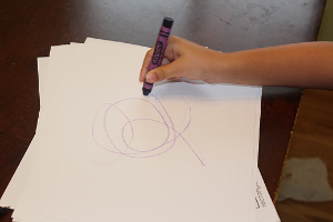 child scribbling on a paper