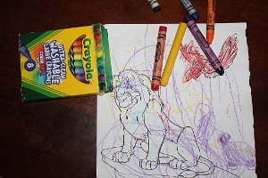 large crayons on a scribbled on coloring page