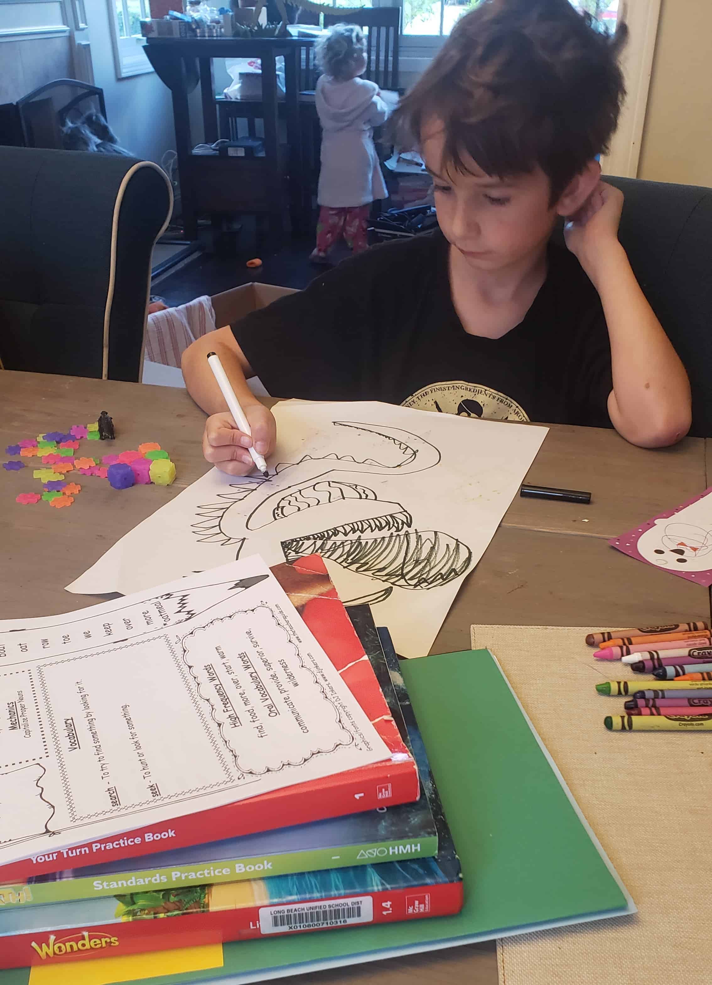 Child drawing artwork at the table. 